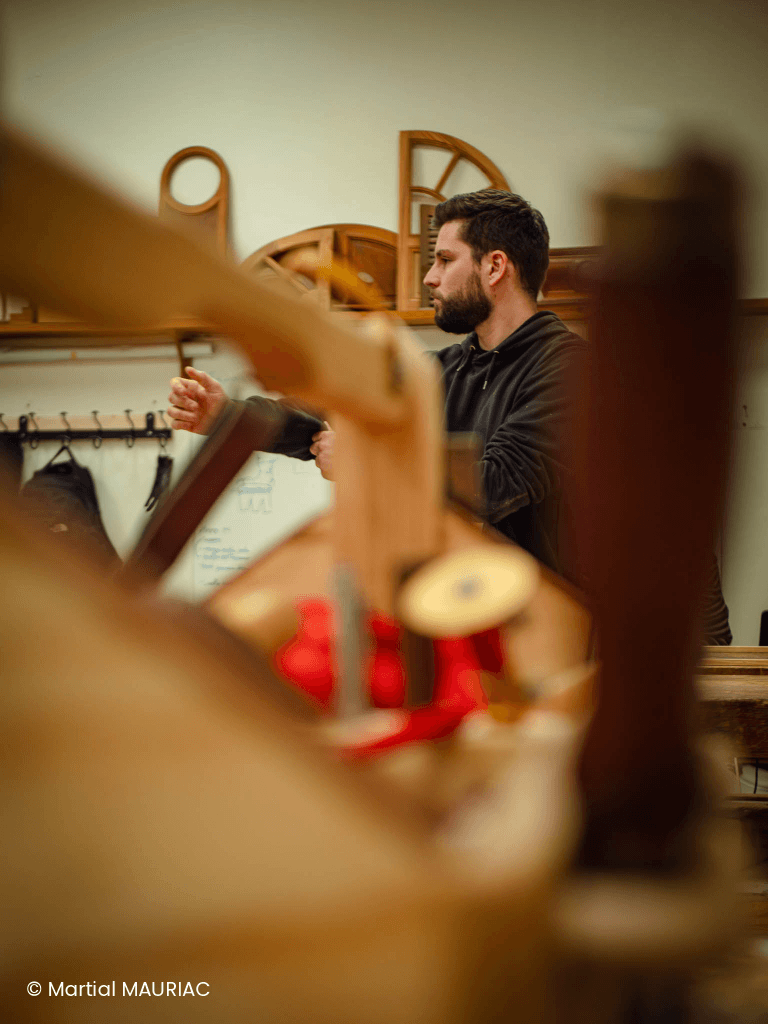 Vue d'ensemble de l'atelier d'ébénisterie de la Philomathique de Bordeaux avec des apprenants en pleine pratique artisanale.