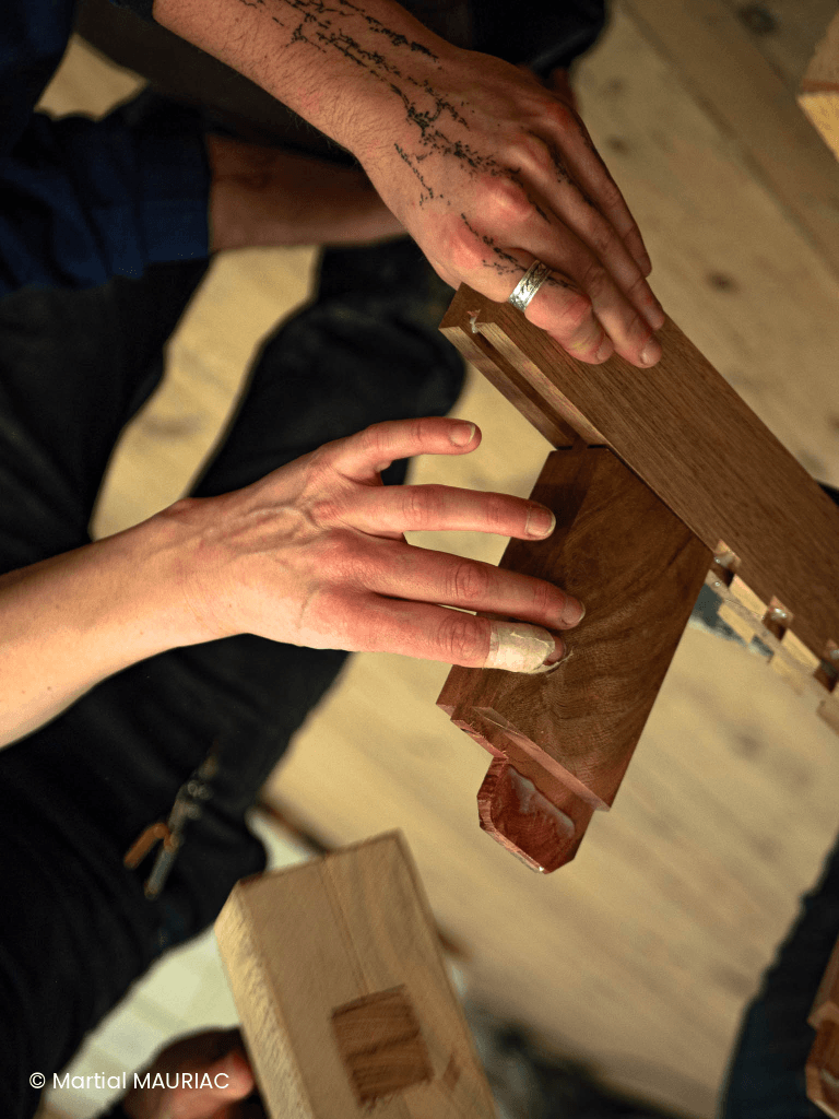 Assemblage et mise sous presse d'un meuble en bois à l'aide de serre-joints dans l'atelier d'ébénisterie de la Philomathique.